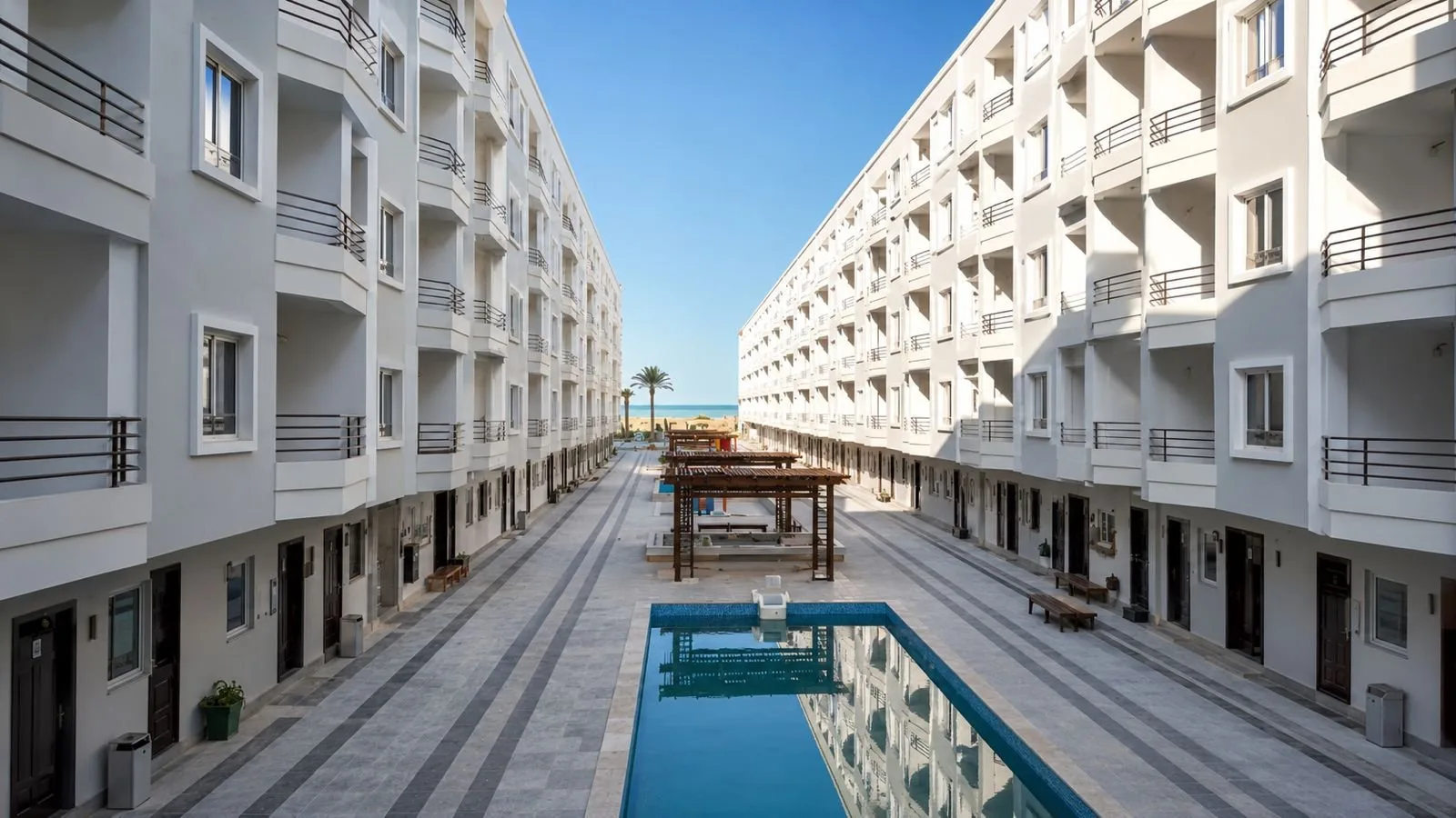صورة حقيقية: Courtyard pool and pergolas looking towards the sea, October 2026