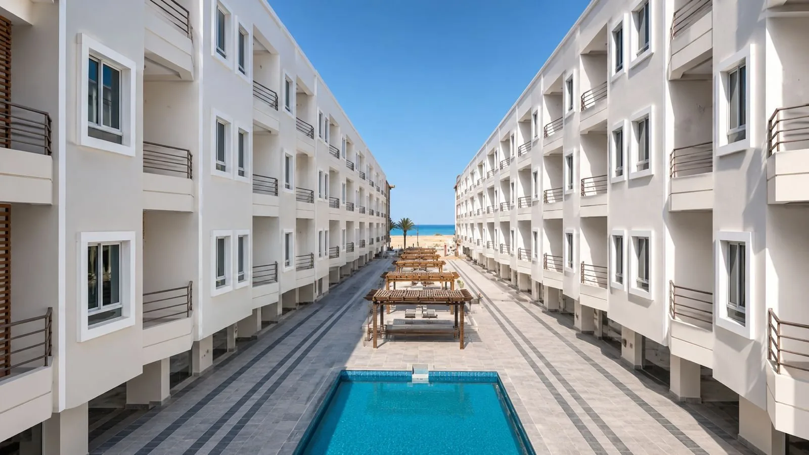 صورة حقيقية: Courtyard pool with the El Mamsha promenade and the sea beyond, site photo, October 2026